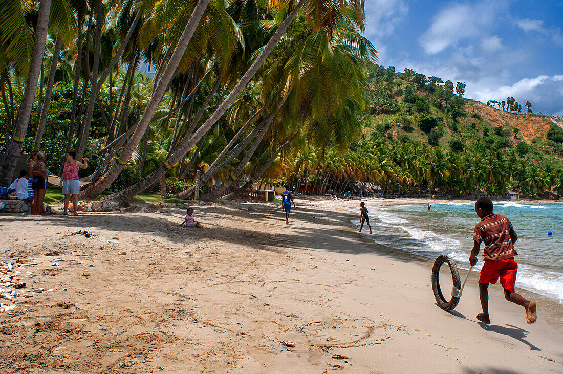 Einheimische Kinder spielen am Strand Plage de Ti Mouillage in Cayes-de-Jacmel, Cayes de Jacmel, Jacmel, Haiti.