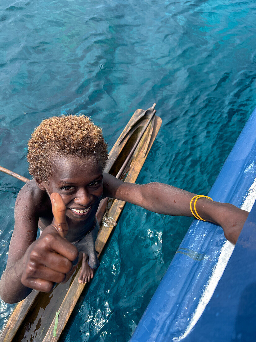 Residents of Tungelo Island in their traditional dugout canoes, New Ireland province, Papua New Guinea