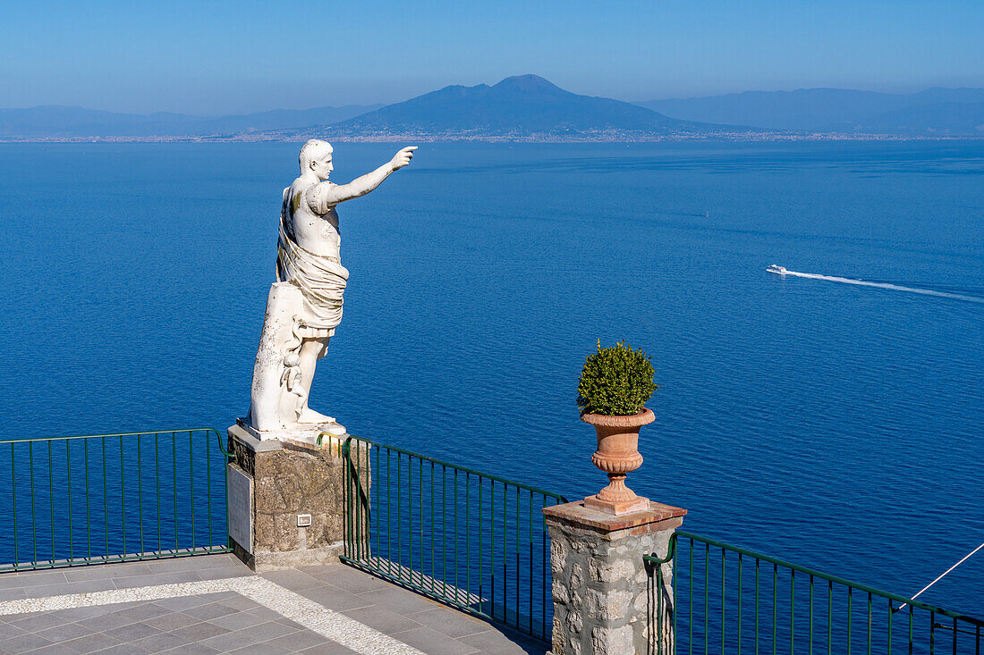 A statue of Augustus Caesar on a cliff-top patio at the Hotel Augustus Caesar in Anacapri, Capri, Italy. Mount Vesuvius is visible across the Bay of Naples.