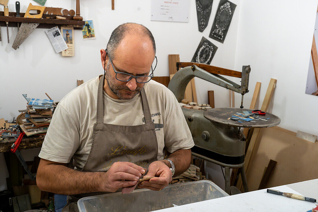 Handwerksmeister Antonino Guarracino bei der Arbeit an Holzintarsien und Laminatschmuck in Sorrento, Italien.