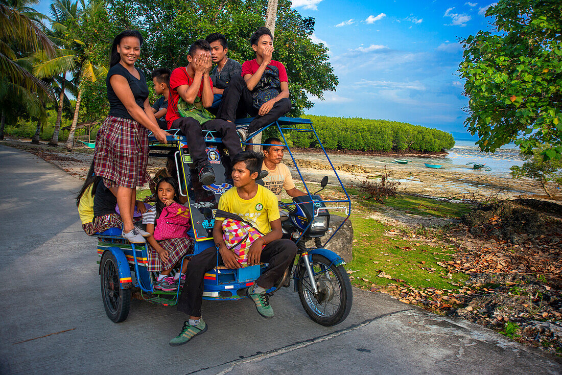 Local students, fanny many people driving a motorcyce in Sipaway Island, San Carlos City, Negros Occidental, Philippines