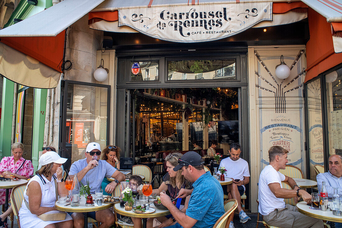 Menschen sitzen im Café-Restaurant Carrousel de Rennes in einer Allee in Montparnasse Paris Frankreich EU Europa