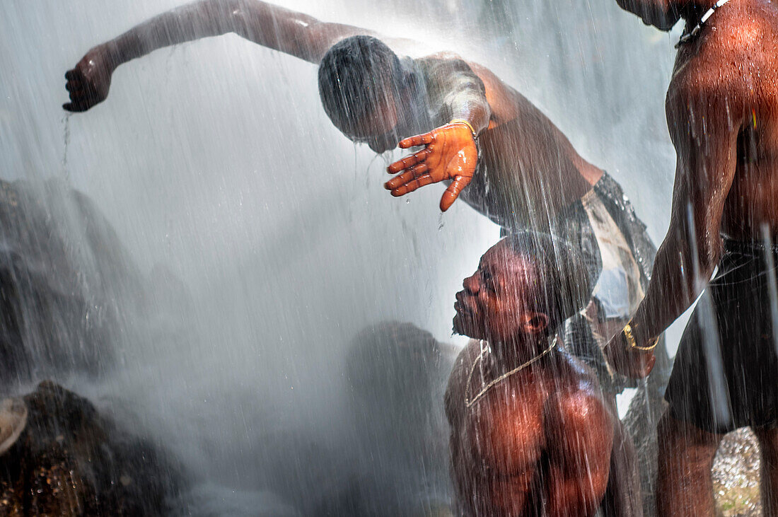 Haiti Voodoo Festival in Saut d'Eau, in Saut d'Eau, Ville Bonheur, Haiti. Tausende von Vodou- und katholischen Anhängern versammelten sich unter dem Wasserfall von Saut d'Eau in Haiti. Die Wallfahrt, die sowohl von Voodou-Anhängern als auch von Katholiken unternommen wird, hat ihren Ursprung in der Sichtung des Bildes der Jungfrau Maria auf einem Palmblatt in der Nähe des Wasserfalls vor einem halben Jahrhundert. Der Katholizismus und die Voodou-Praktiken sind in ihrer haitianischen Form für immer miteinander verwoben. Das Erscheinen eines Regenbogens unter den Wasserfällen soll bedeuten, dass