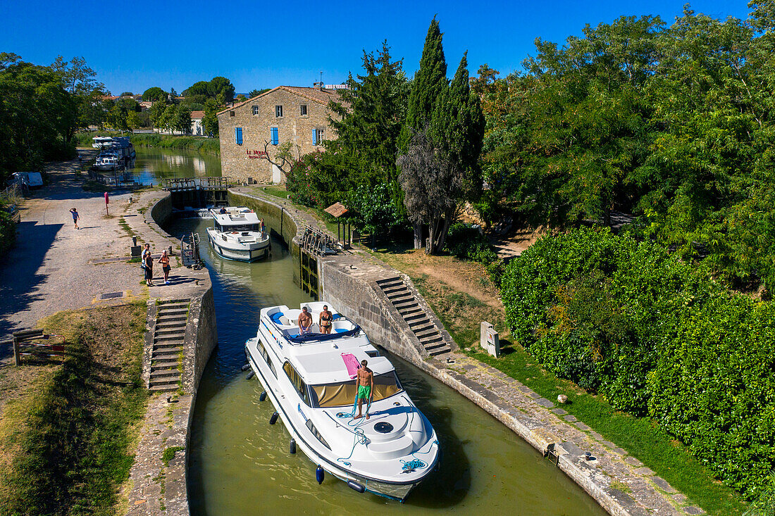 Aerial view of the triple écluse des moulins de Trèbes look aux portes du Minervois. Canal du Midi at village of Puichéric Carcassone Aude South of France southern waterway waterways holidaymakers queue for a boat trip on the river, France, Europe