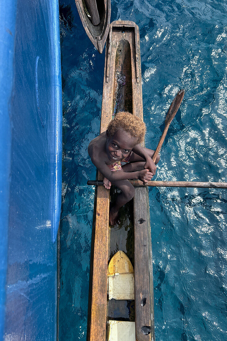 Residents of Tungelo Island in their traditional dugout canoes, New Ireland province, Papua New Guinea