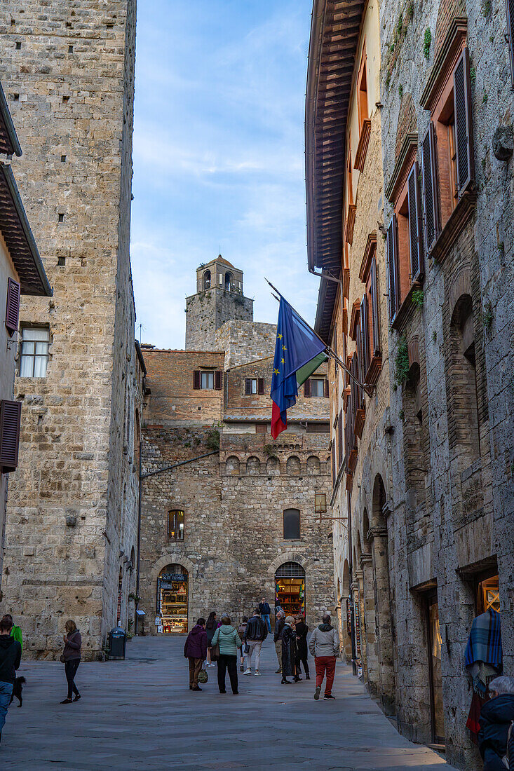 The top of the Torre Rognosa above buildings on Via San Giovanni in the medieval city of San Gemignano, Italy.