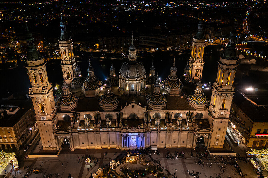 Aerial view of the Cathedral Basilica of of Our Lady of the Pillar and El Pilar square illuminated at night during Christmas, Zaragoza, Spain