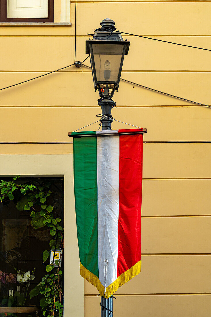 Ein Banner mit der italienischen Flagge an einer Straßenlaterne im historischen Zentrum der Stadt Sorrent, Italien.