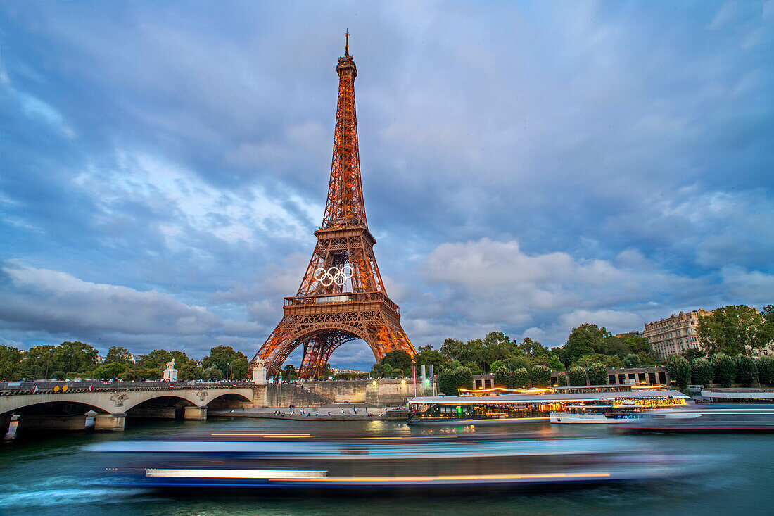 Panorama des Eiffelturms, der Seine und der Pont d'lena in Paris, Frankreich, mit einer vorbeifahrenden Kreuzfahrtfähre.