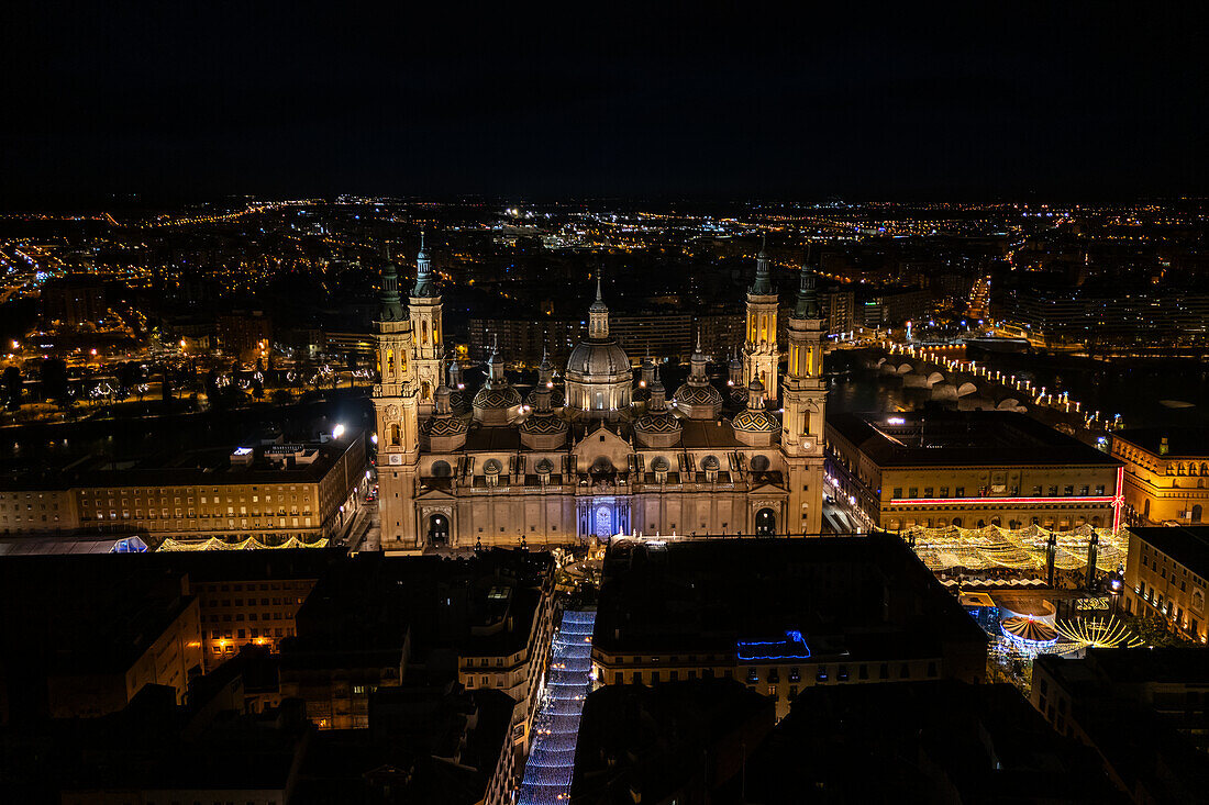 Luftaufnahme der Kathedrale Basilika Unserer Lieben Frau von der Säule und der nächtlich beleuchteten Alfonso-Straße während der Weihnachtszeit, Zaragoza, Spanien