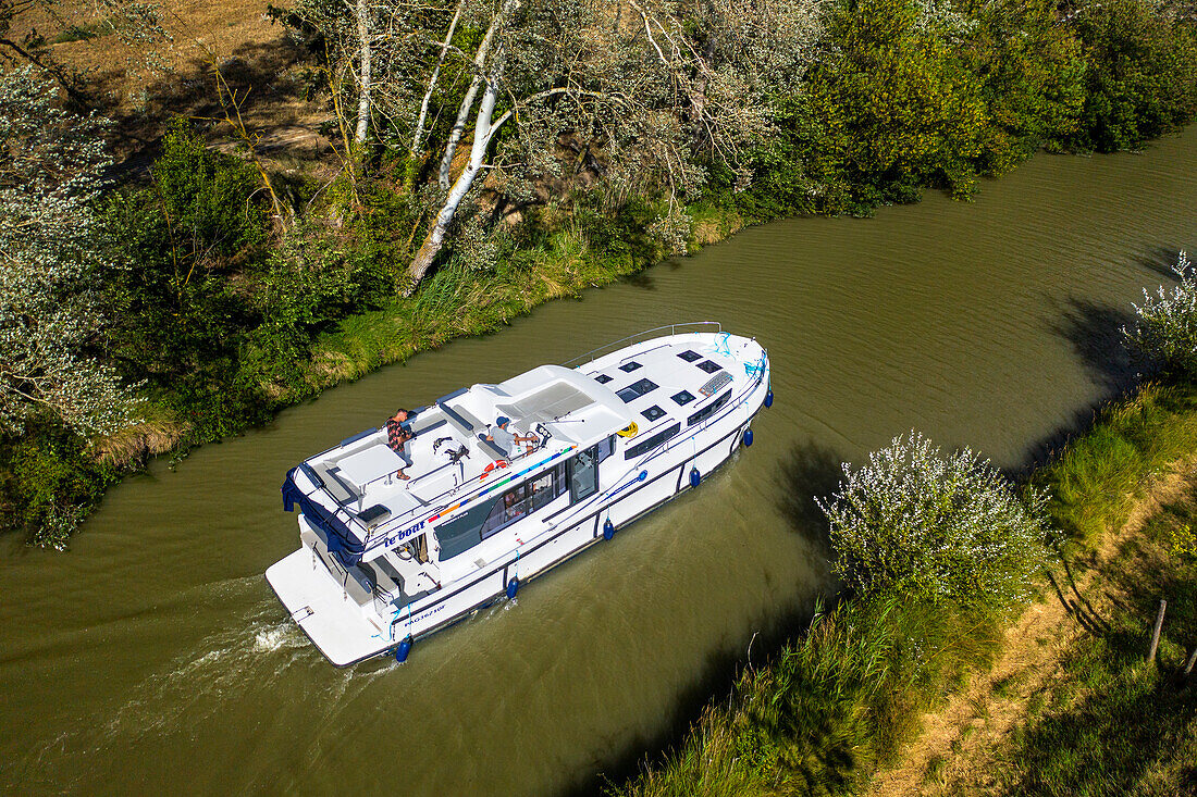 Aerial view of a boat in the Canal du Midi at Le Somail Aude South of France southern waterway waterways holidaymakers queue for a boat trip on the river, France, Europe