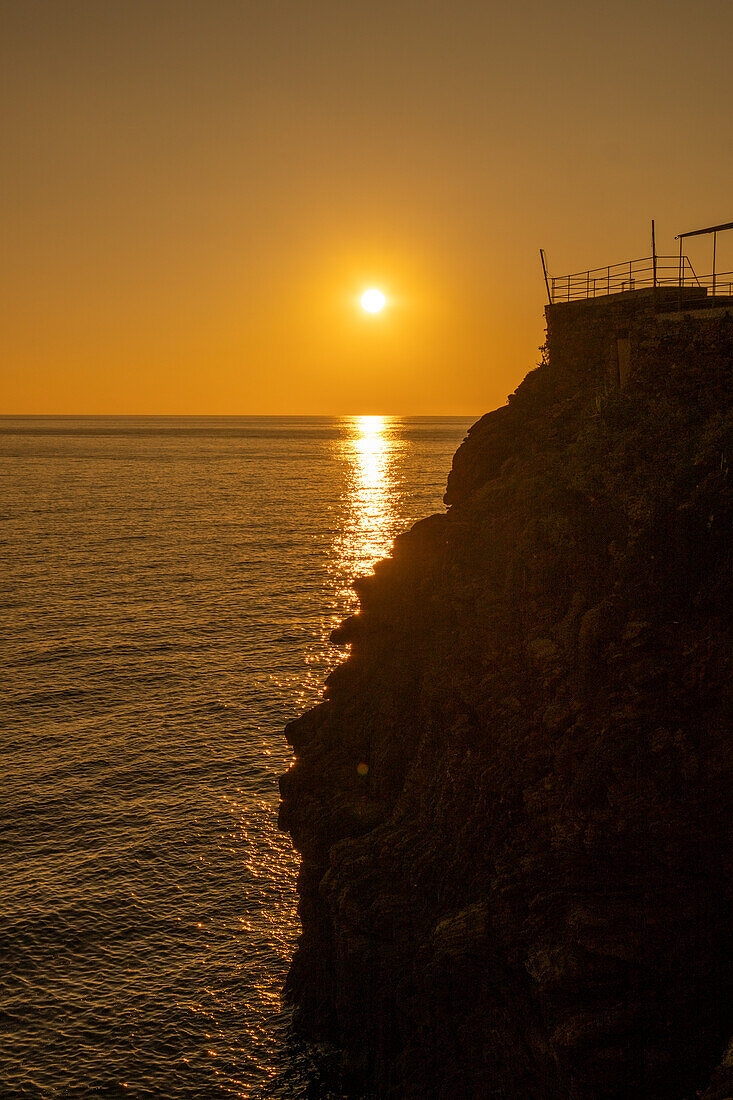 Silhouette der Felsen und eine bunte untergehende Sonne über dem Lingurischen Meer bei Riomaggiore, Cinque Terre, Italien.