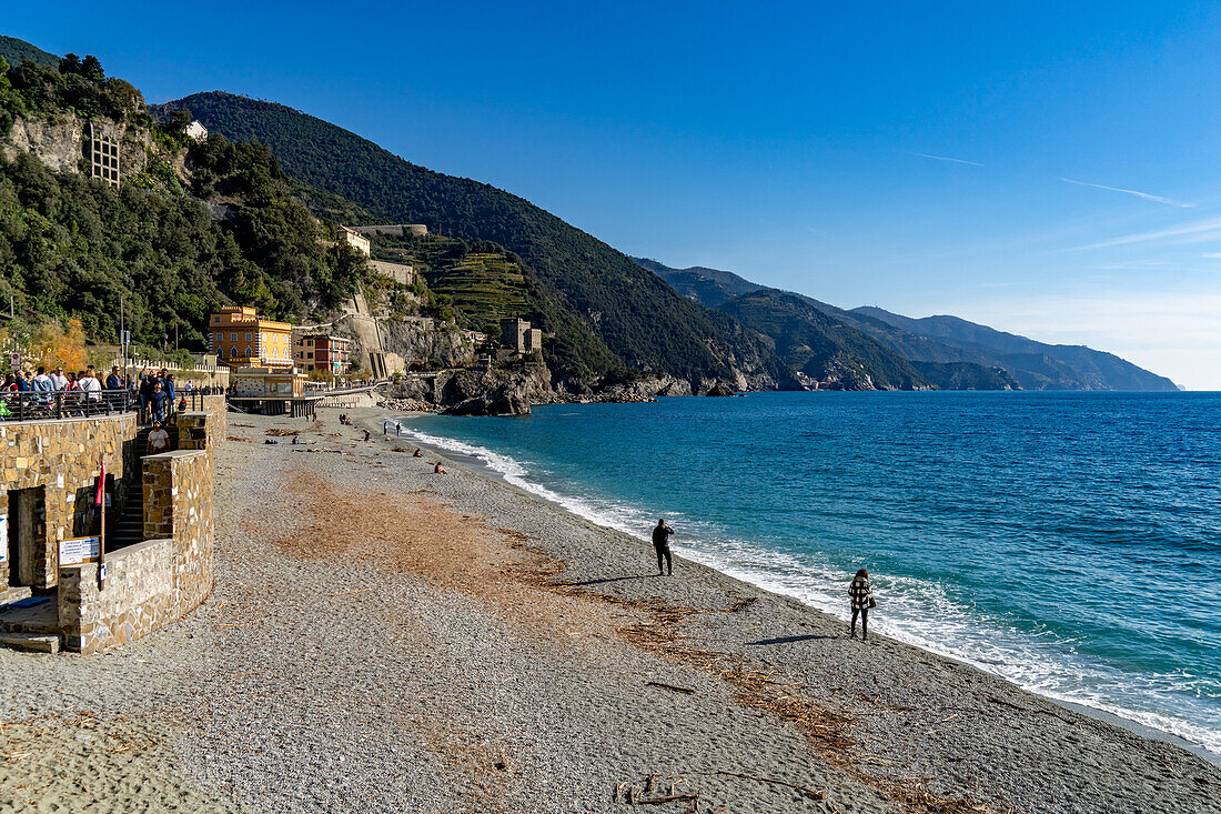 Touristen am Strand in der Nebensaison in Monterosso al Mare, Cinque Terre, Italien.