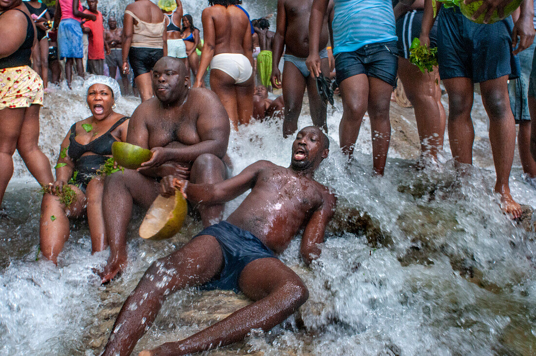 Haiti Voodoo Festival in Saut d'Eau, in Saut d'Eau, Ville Bonheur, Haiti. Tausende von Vodou- und katholischen Anhängern versammelten sich unter dem Wasserfall von Saut d'Eau in Haiti. Die Wallfahrt, die sowohl von Voodou-Anhängern als auch von Katholiken unternommen wird, hat ihren Ursprung in der Sichtung des Bildes der Jungfrau Maria auf einem Palmblatt in der Nähe des Wasserfalls vor einem halben Jahrhundert. Der Katholizismus und die Voodou-Praktiken sind in ihrer haitianischen Form für immer miteinander verwoben. Das Erscheinen eines Regenbogens unter den Wasserfällen soll bedeuten, dass