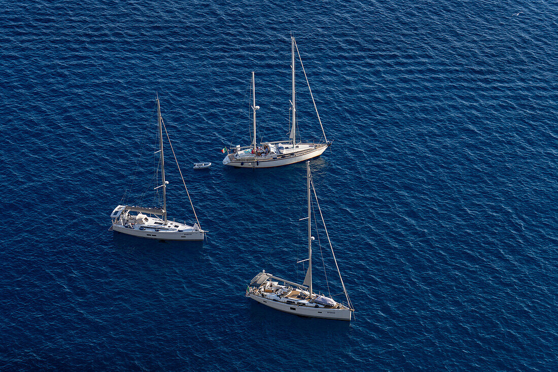 Sailboats in the waters of the Tyrrhenian Sea off the coast of the island of Capri, Italy.