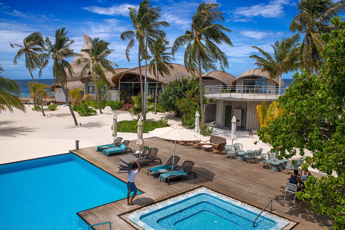 Swimming pool and restaurant of the Outrigger maldives Maafushivaru luxury resort, South Ari Atoll region Maldives