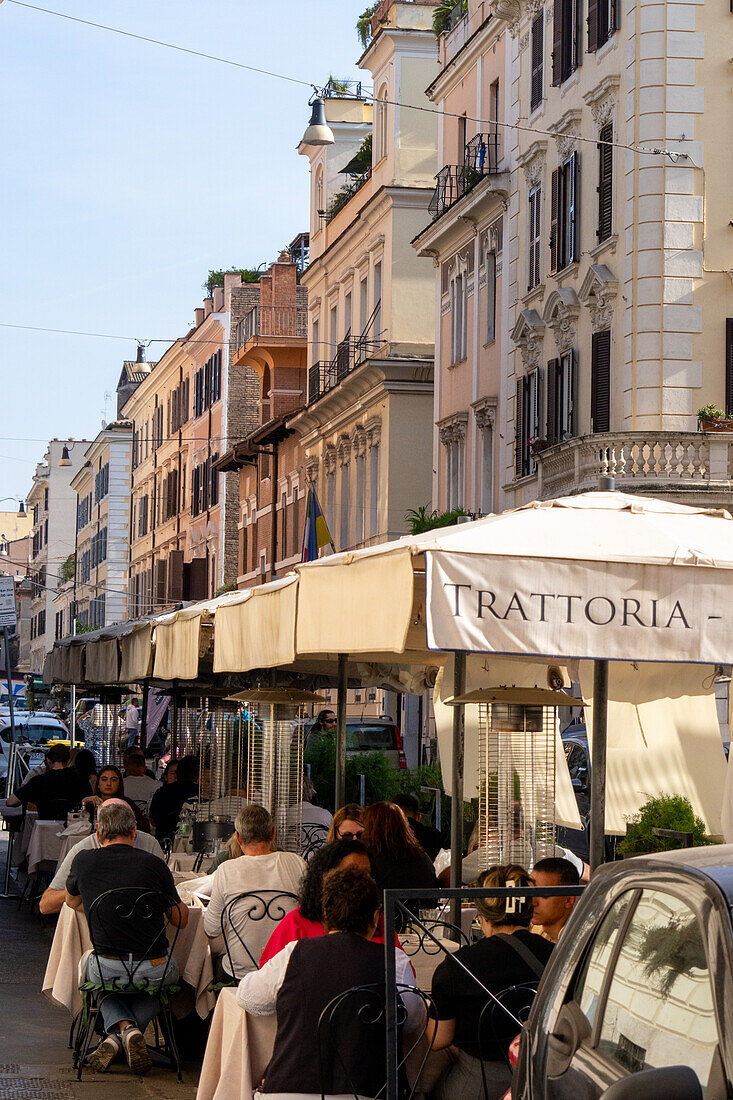 People eating in an outdoor restaurant on a street in Rome, Italy.