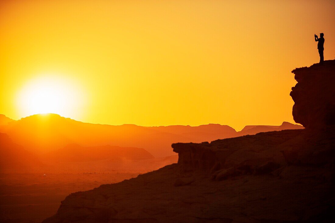 Touristen fotografieren den roten Sand der Wüste von Wadi Rum bei Sonnenuntergang, Jordanien