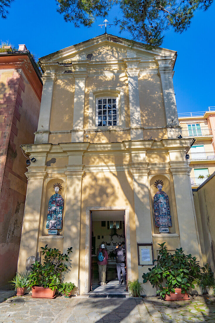 Die kleine Kirche Santa Maria Nascente in der Gegend von Fegina in Monterosso al Mare, Cinque Terre, Italien. Die Statuen an der Fassade sind der Heilige Andreas und der Heilige Dominikus.