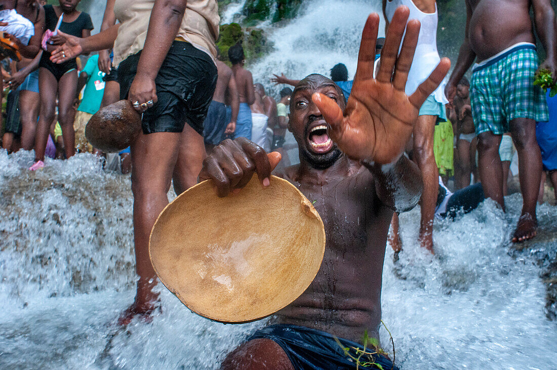 Haiti Voodoo Festival in Saut d'Eau, in Saut d'Eau, Ville Bonheur, Haiti. Thousands of both Vodou and Catholic followers gathered under the Saut d'Eau waterfall in Haiti. The pilgrimage, made by Voodou practitioners and Catholics alike, originated with the sighting of the likeness of the Virgin Mary on a palm leaf close to the falls half a century ago. Catholism and Voodou practices are forever intertwined in its Haitian form. The appearance of a rainbow beneath the falls is said indicate that Danbala - the great lord of the waterfall - and Ayida Wedo - the rainbow - are making love. Fertility