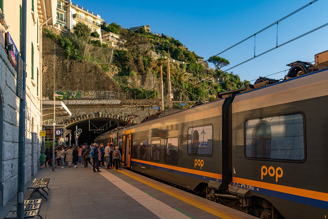 Passengers board a Trenitalia Pop passenger train at the station in Riomaggiore, Italy. The Pop is a Coradia Stream built by Alstom.