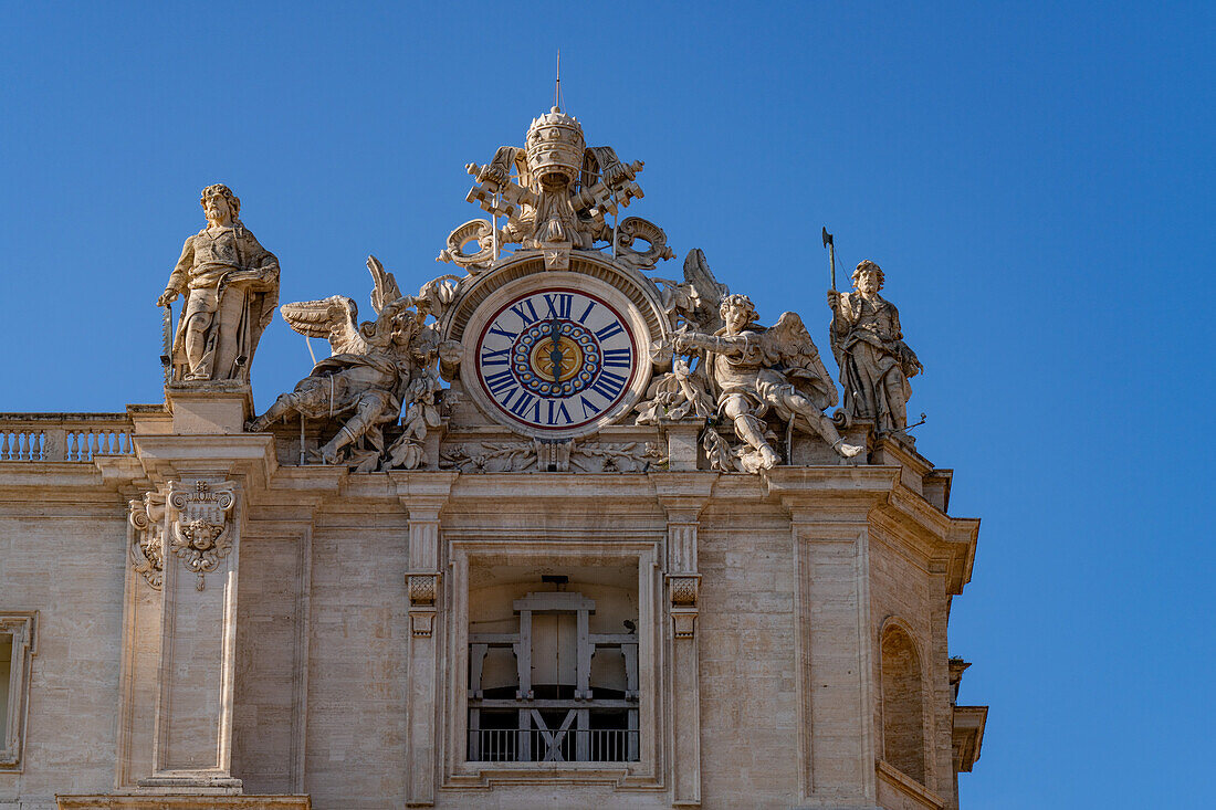 A clock and statues on the facade of Saint Peter's Basilica in Vatican City in Rome, Italy.