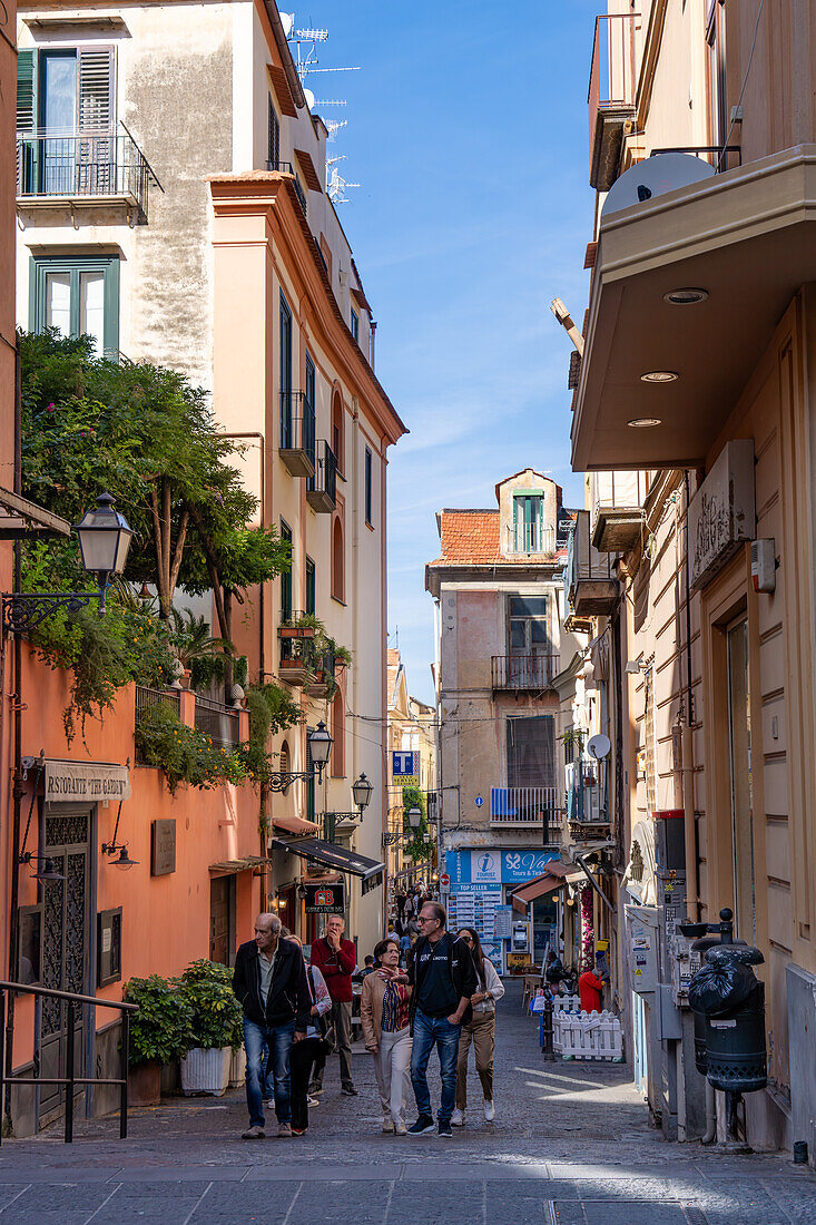 Tourists walking on the narrow Via Torquao Tasso in the historic center of Sorrento, Italy.