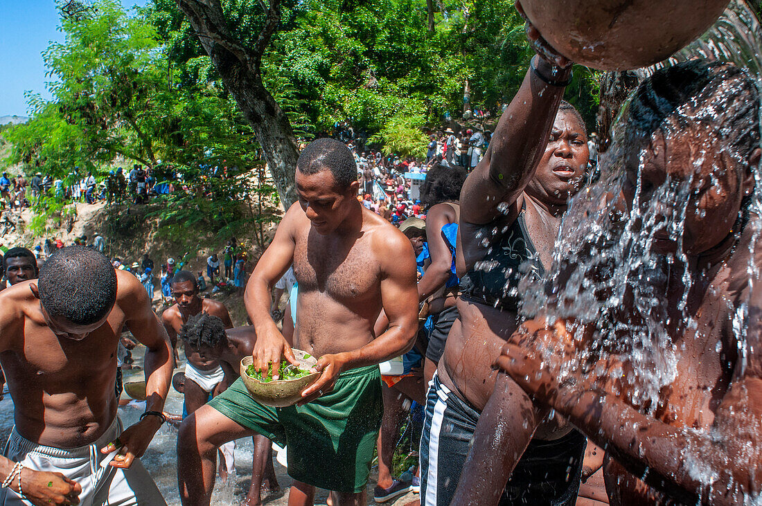 Haiti Voodoo Festival in Saut d'Eau, in Saut d'Eau, Ville Bonheur, Haiti. Thousands of both Vodou and Catholic followers gathered under the Saut d'Eau waterfall in Haiti. The pilgrimage, made by Voodou practitioners and Catholics alike, originated with the sighting of the likeness of the Virgin Mary on a palm leaf close to the falls half a century ago. Catholism and Voodou practices are forever intertwined in its Haitian form. The appearance of a rainbow beneath the falls is said indicate that Danbala - the great lord of the waterfall - and Ayida Wedo - the rainbow - are making love. Fertility