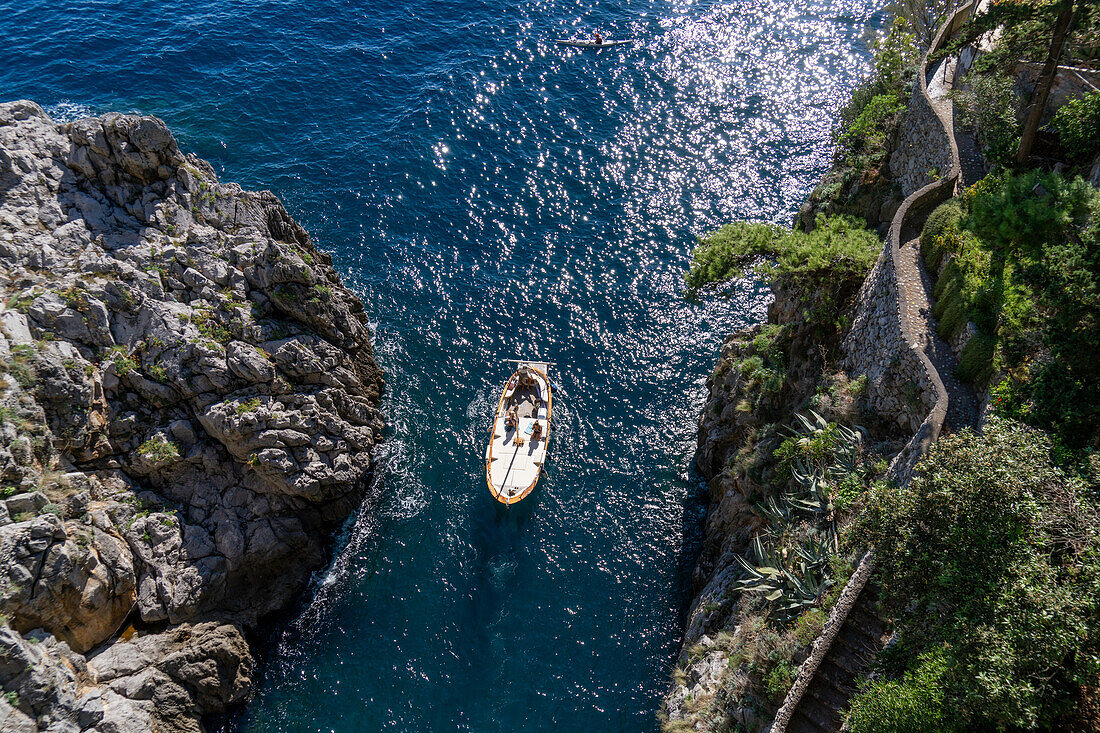 Ein kleines traditionelles Fischerboot mit Touristen nähert sich der Mündung des Furore-Fjords an der Amalfiküste, Italien.