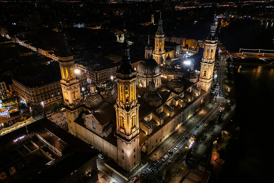 Luftaufnahme der nächtlich beleuchteten Kathedrale Unserer Lieben Frau von der Säule während der Weihnachtszeit in Zaragoza, Spanien