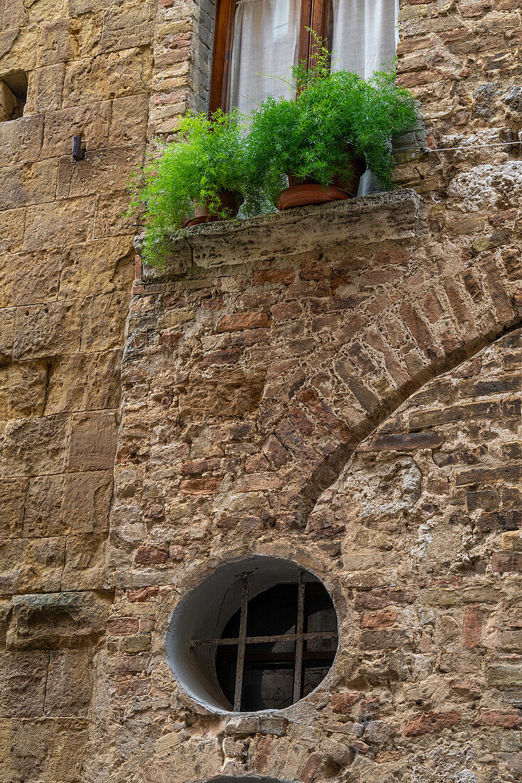 Detail eines Gebäudes an der Via San Matteo in der mittelalterlichen Stadt San Gimignano, Italien.