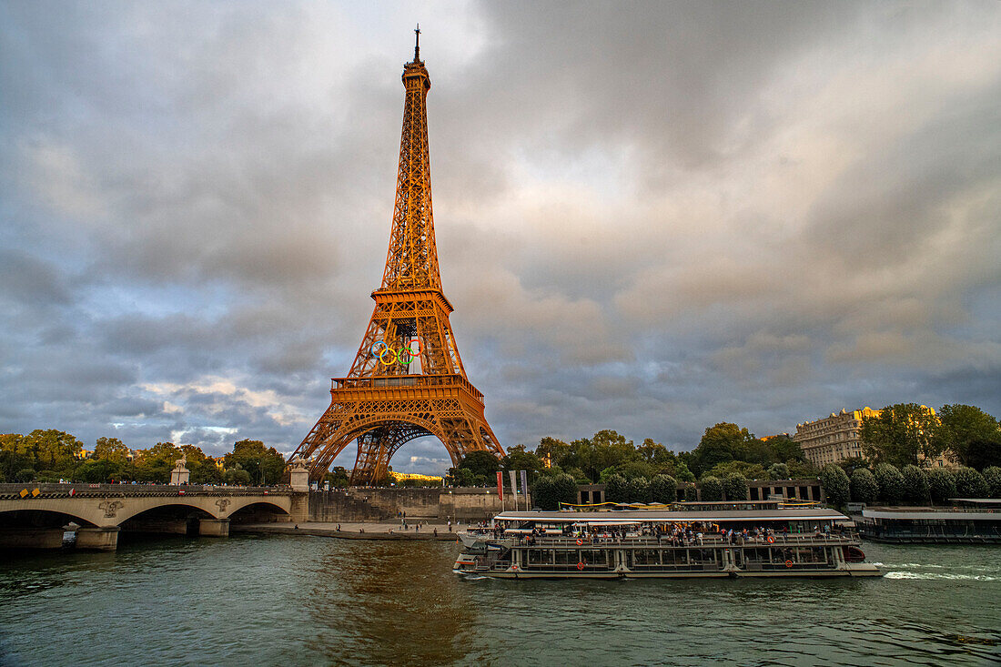 Scenic panorama of Eiffel Tower, Seine River, and pont d'lena in Paris, France; with a cruise passing by ferry