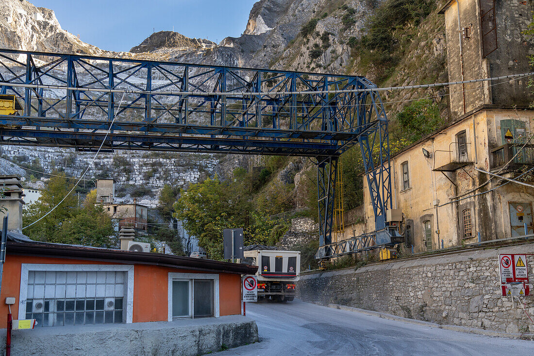 Ein Portalkran für den Transport großer Marmorblöcke in der Nähe der Steinbrüche in Fantiscriiti, in der Nähe von Carrara, Italien. Die Steinbrüche sind auf dem Berg dahinter zu sehen.