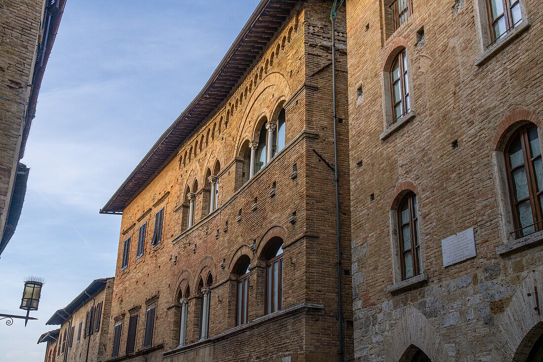 Ein mittelalterlicher Palast mit gotischer Architektur in der Via San Matteo in der ummauerten Stadt San Gimignano, Italien.