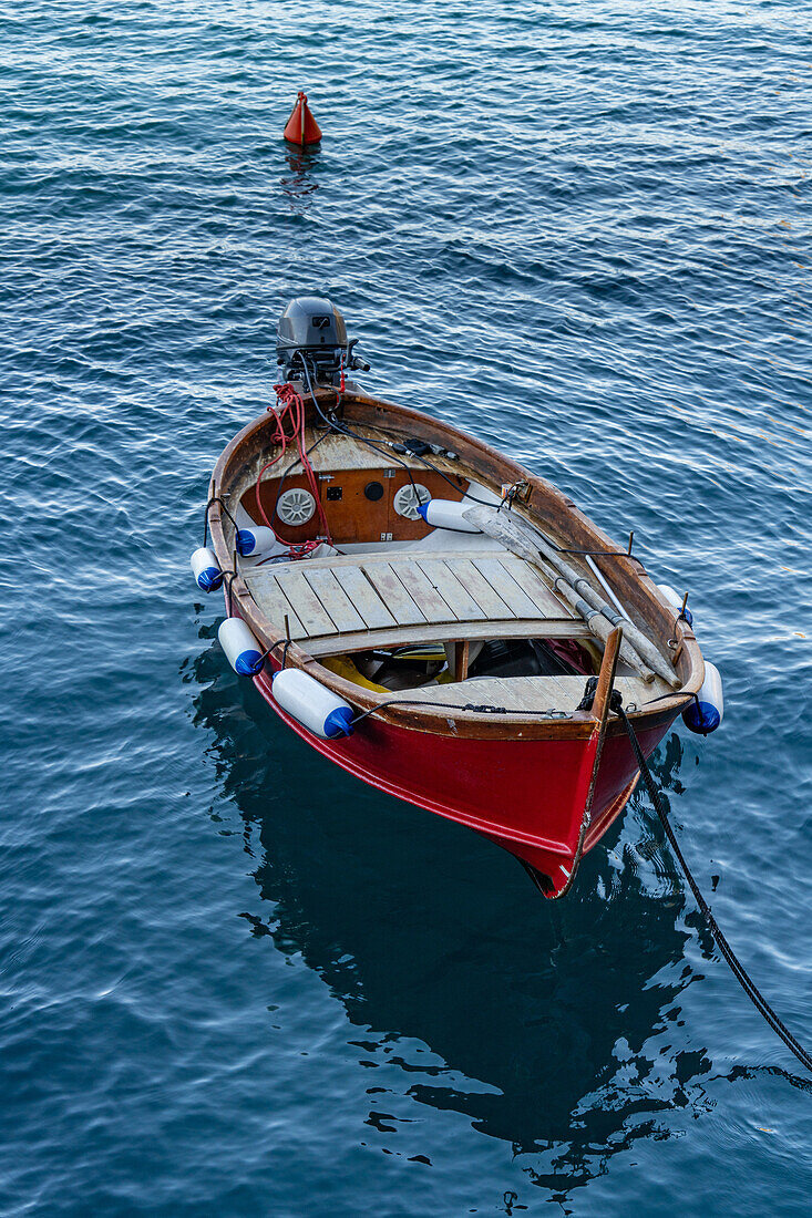 A small wooden fishing boat moored in the harbor of the fishing village of Manarola, Cinque Terre, Italy.