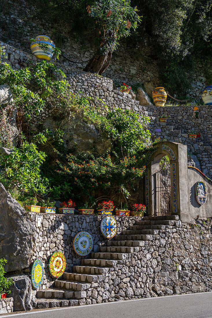 Large, colorful ceramic tabletops decorate a stone staircase at a ceramic shop on the Amalfi Coast of Italy.