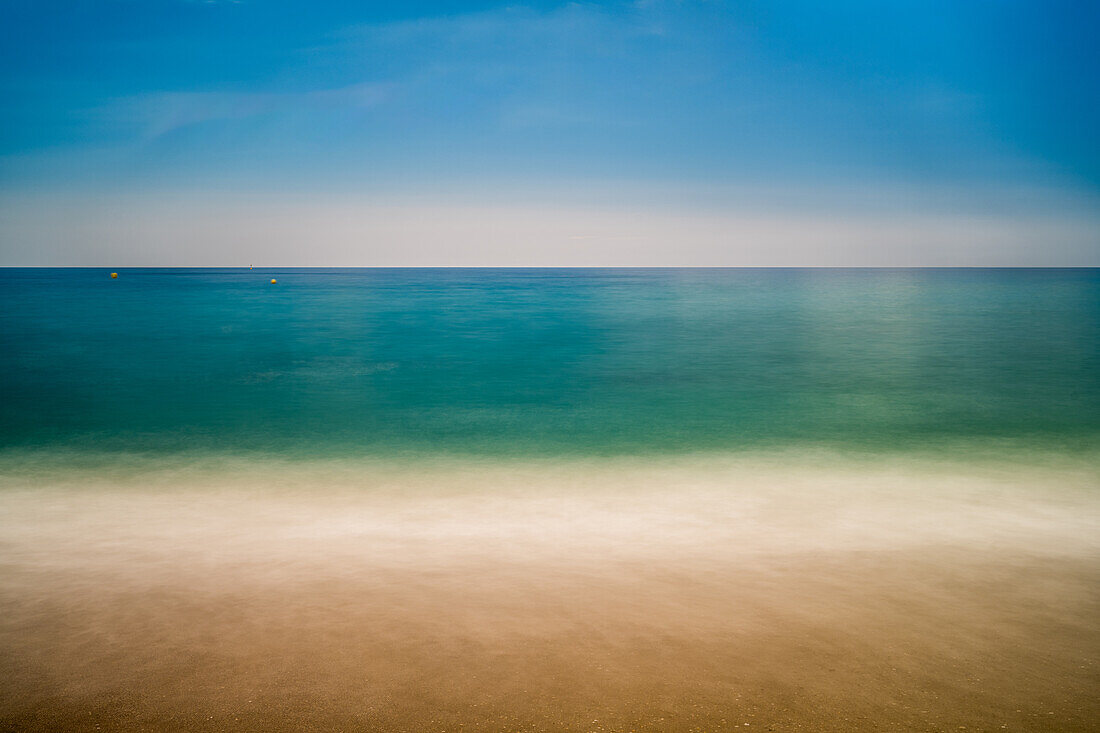 Long exposure captures the tranquil waters and sandy shores of Nerjas coastline.