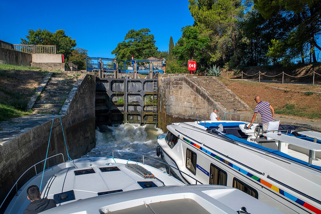 Boot bei der Überquerung der dreifachen Écluse de Fonfile look au Ranchin. Canal du Midi bei Puichéric Carcassone Aude Südfrankreichs südliche Wasserstraße Wasserstraßen Urlauber stehen Schlange für eine Bootsfahrt auf dem Fluss, Frankreich, Europa