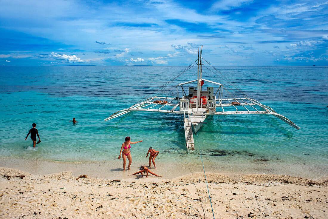 Traditional boats moored off a tiny tropical island beach in the Philippines Kalanggaman island, Malapascua, Cebu, Philippines