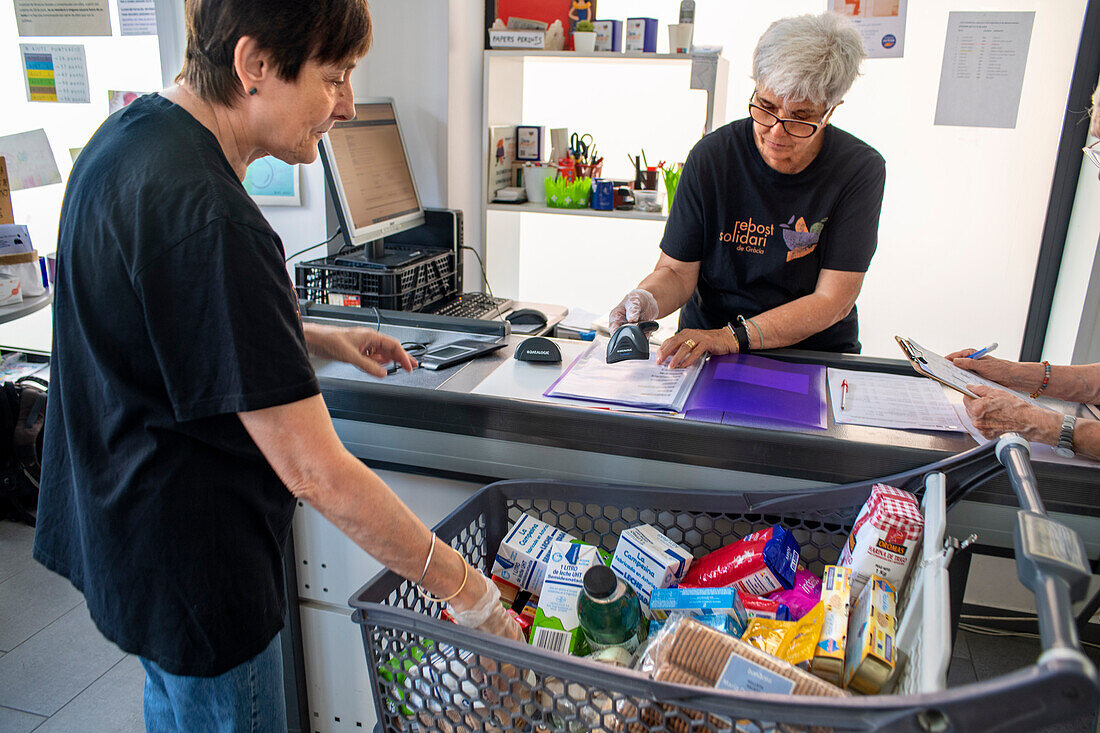 Arme und bedürftige Familien sammeln gespendete Produkte im Supermarkt Rebost Solidari de Gracia, Stadtviertel Gracia, Barcelona, Spanien, Europa. Der Rebost Solidari de Gracia ist eine Vertriebsstelle der Lebensmittelbank in ihren Programmen Sec, SERMA (frisches Obst und Gemüse), Kühlkette (Tiefkühl- und gekühlte Produkte) und FEGA (von der EU erhaltene Produkte). Eine effiziente Verwaltung aller Lebensmittelüberschüsse, die in der Gemeinde anfallen (Märkte, Supermärkte, Geschäfte, Unternehmen, Restaurants, Schulkantinen und andere), ist an sich schon ein wichtiges Ziel, sowohl für die Verwen