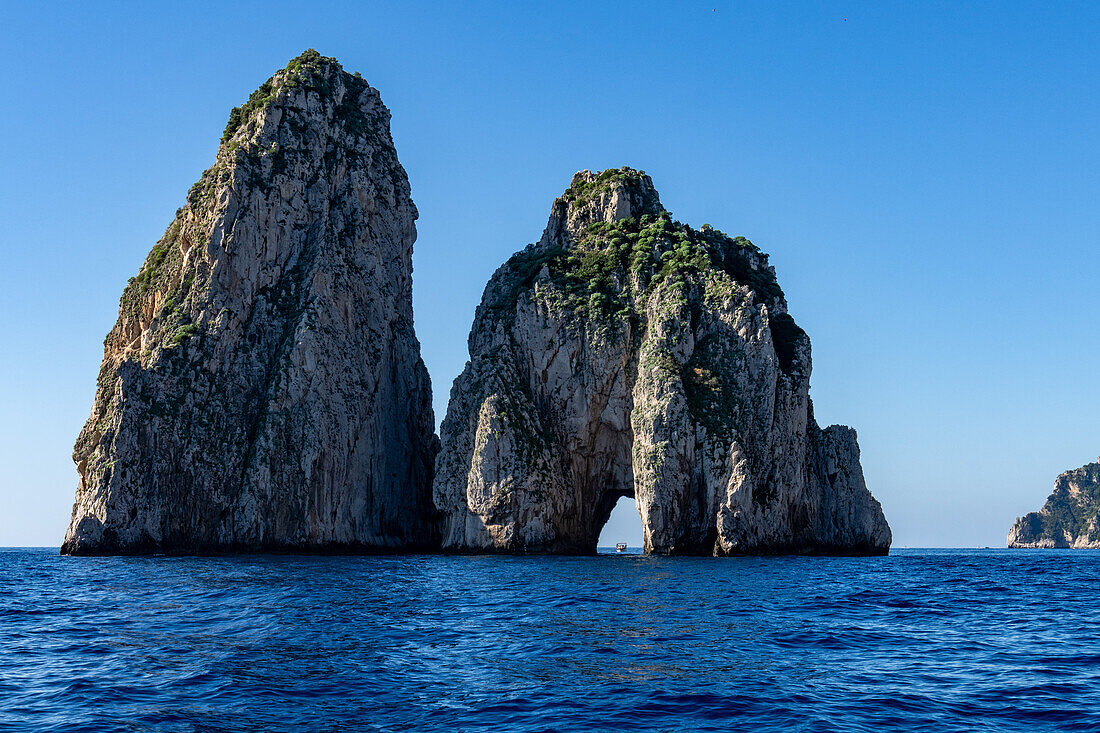 Die Farallons oder Faraglioni, Meeresfelsen vor der Küste der Insel Capri, Italien. L-R: Scopolo oder Fuori & Mezzo mit seinem Meeresbogen.