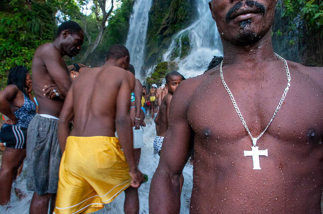 Haiti Voodoo Festival in Saut d'Eau, in Saut d'Eau, Ville Bonheur, Haiti. Tausende von Vodou- und katholischen Anhängern versammelten sich unter dem Wasserfall von Saut d'Eau in Haiti. Die Wallfahrt, die sowohl von Voodou-Anhängern als auch von Katholiken unternommen wird, hat ihren Ursprung in der Sichtung des Bildes der Jungfrau Maria auf einem Palmblatt in der Nähe des Wasserfalls vor einem halben Jahrhundert. Der Katholizismus und die Voodou-Praktiken sind in ihrer haitianischen Form für immer miteinander verwoben. Das Erscheinen eines Regenbogens unter den Wasserfällen soll bedeuten, dass