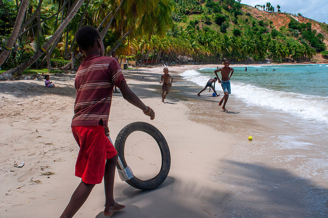 Einheimische Kinder spielen am Strand Plage de Ti Mouillage in Cayes-de-Jacmel, Cayes de Jacmel, Jacmel, Haiti.