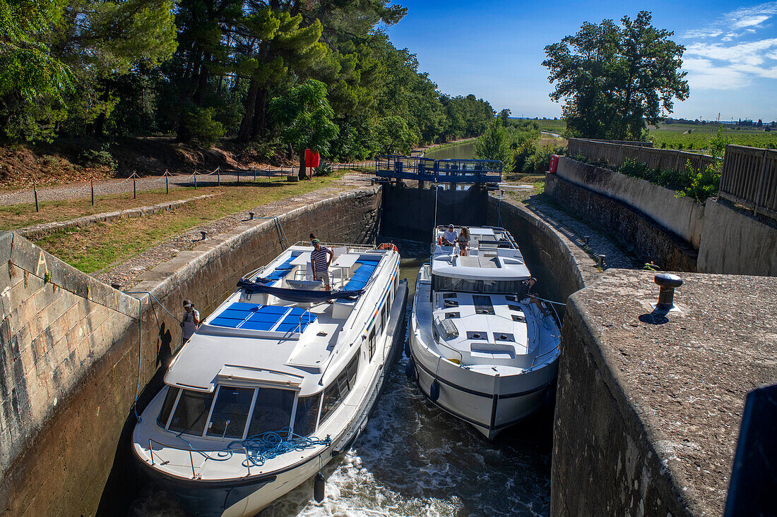 Boot bei der Überquerung der dreifachen Écluse de Fonfile look au Ranchin. Canal du Midi bei Puichéric Carcassone Aude Südfrankreichs südliche Wasserstraße Wasserstraßen Urlauber stehen Schlange für eine Bootsfahrt auf dem Fluss, Frankreich, Europa