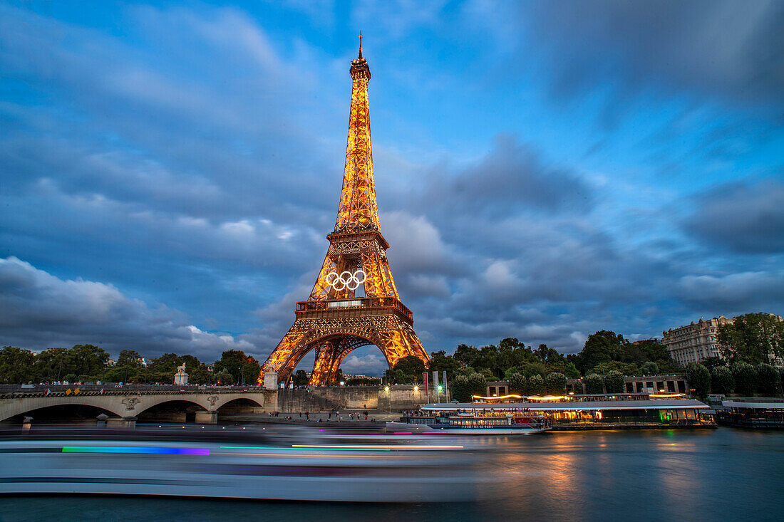 Panorama des Eiffelturms, der Seine und der Pont d'lena in Paris, Frankreich, mit einer vorbeifahrenden Kreuzfahrtfähre.