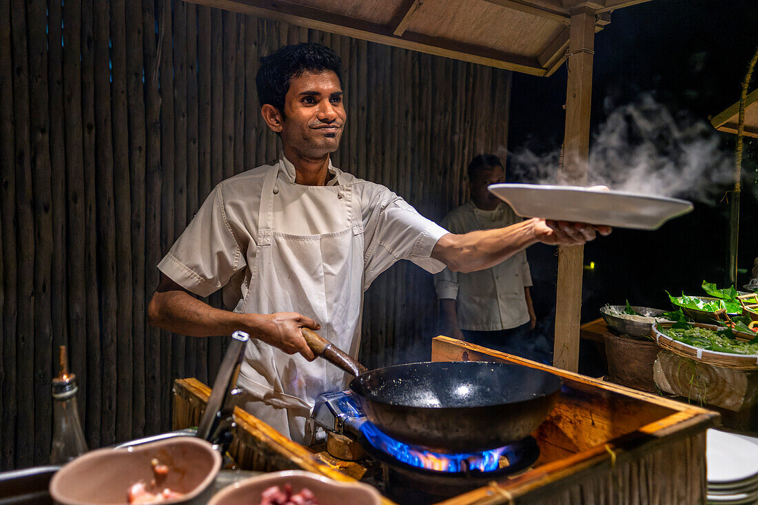 Waiter with a maldivian dish in the water restaurant of Six Senses Laamu maldives luxury resort villas, Laamu Atoll region Maldives