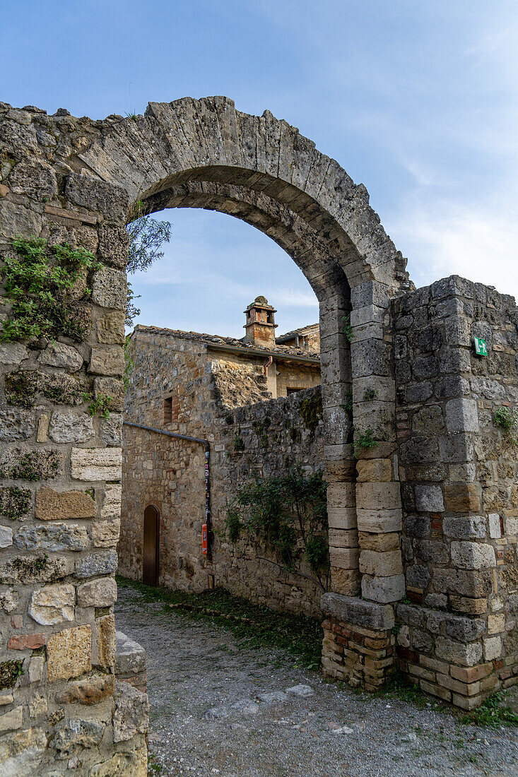 Arched gateway into the Parco della Rocca, the ruins of a medieval fort in the walled town of San Gimignano, Italy.