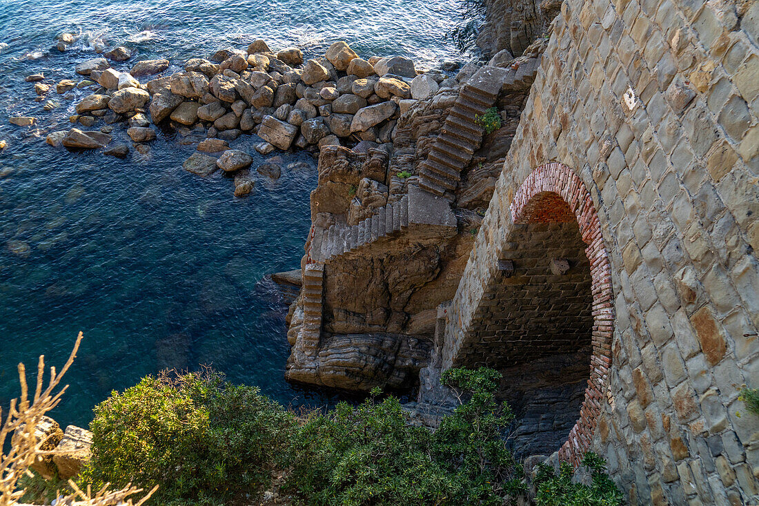 Steile Treppe hinunter zu einem Anlegeseil am Wasser des Lingurischen Meeres bei Riomaggiore, Cinque Terre, Italien.