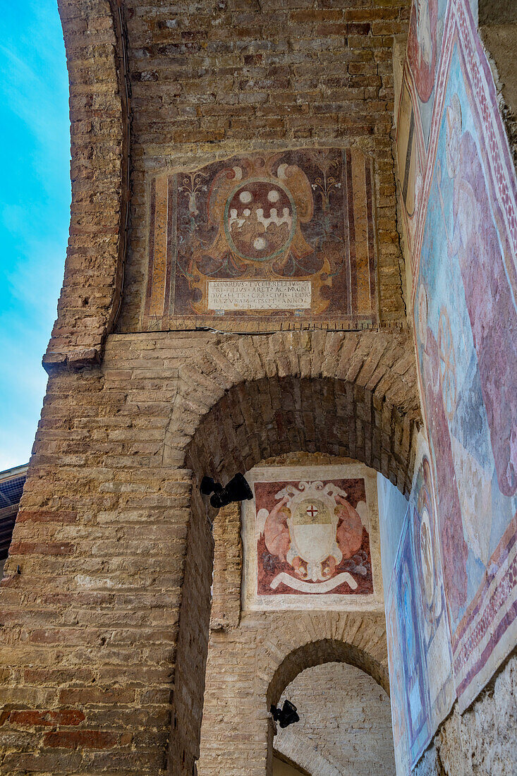 Medieval coats of arms in the courtyard of the Palazzo Comunale or city hall in San Gimignano, Italy.