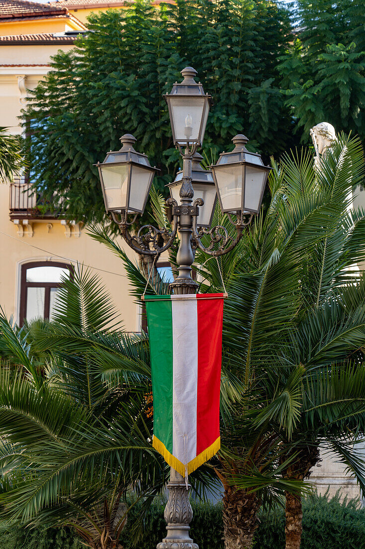 Ein italienisches Flaggenbanner an einer Straßenlaterne auf der Piazza Sant'Antonino im historischen Zentrum von Sorrent, Italien.